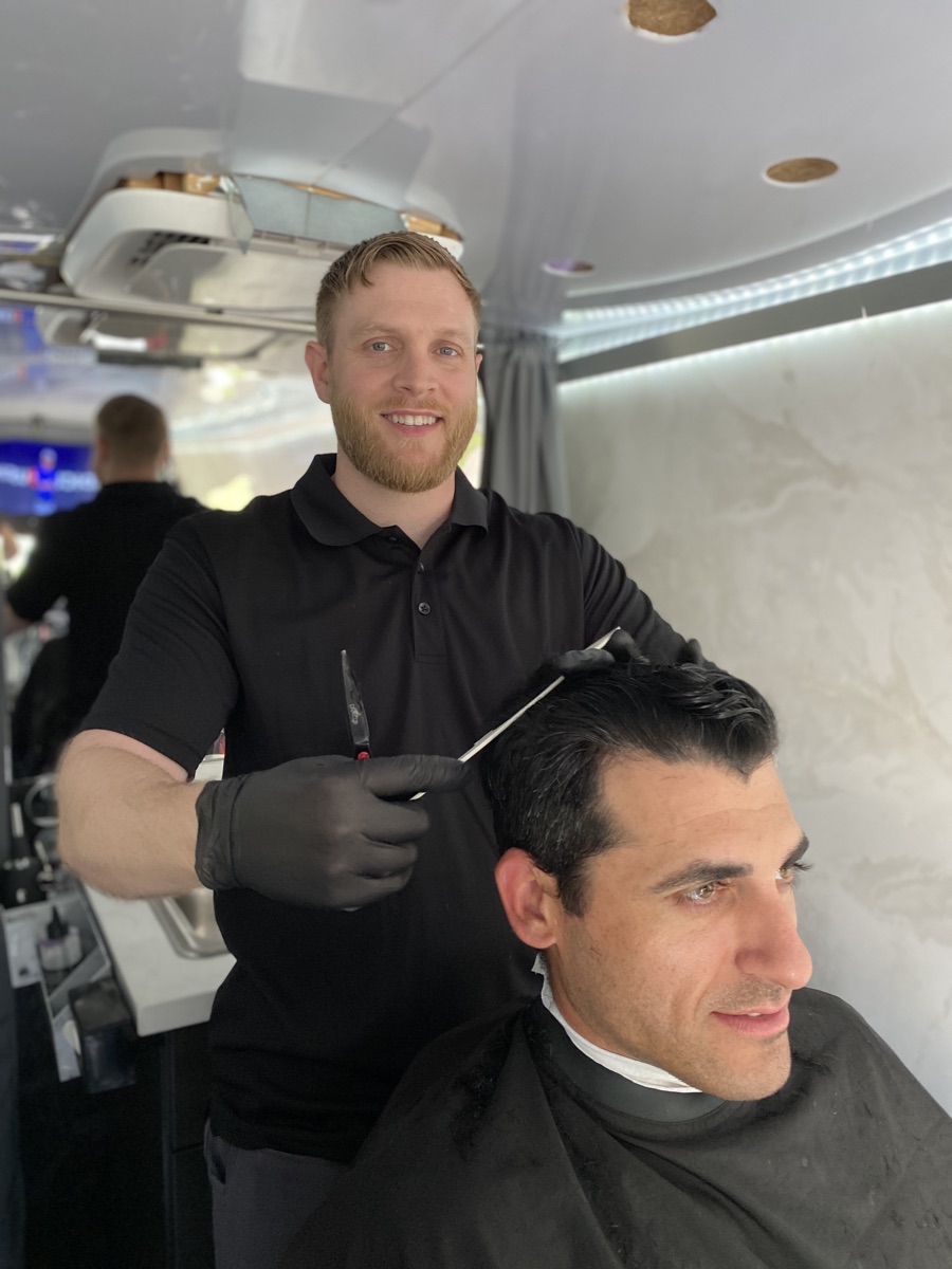 Rory performing a precision haircut inside the mobile barbershop
